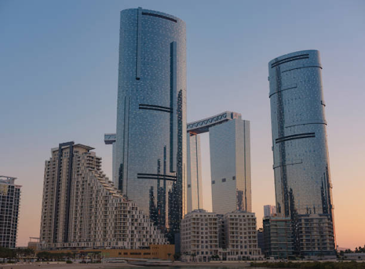 Three modern high-rise residential towers at Damac Hills 2, reflecting luxury and upscale living at dusk.